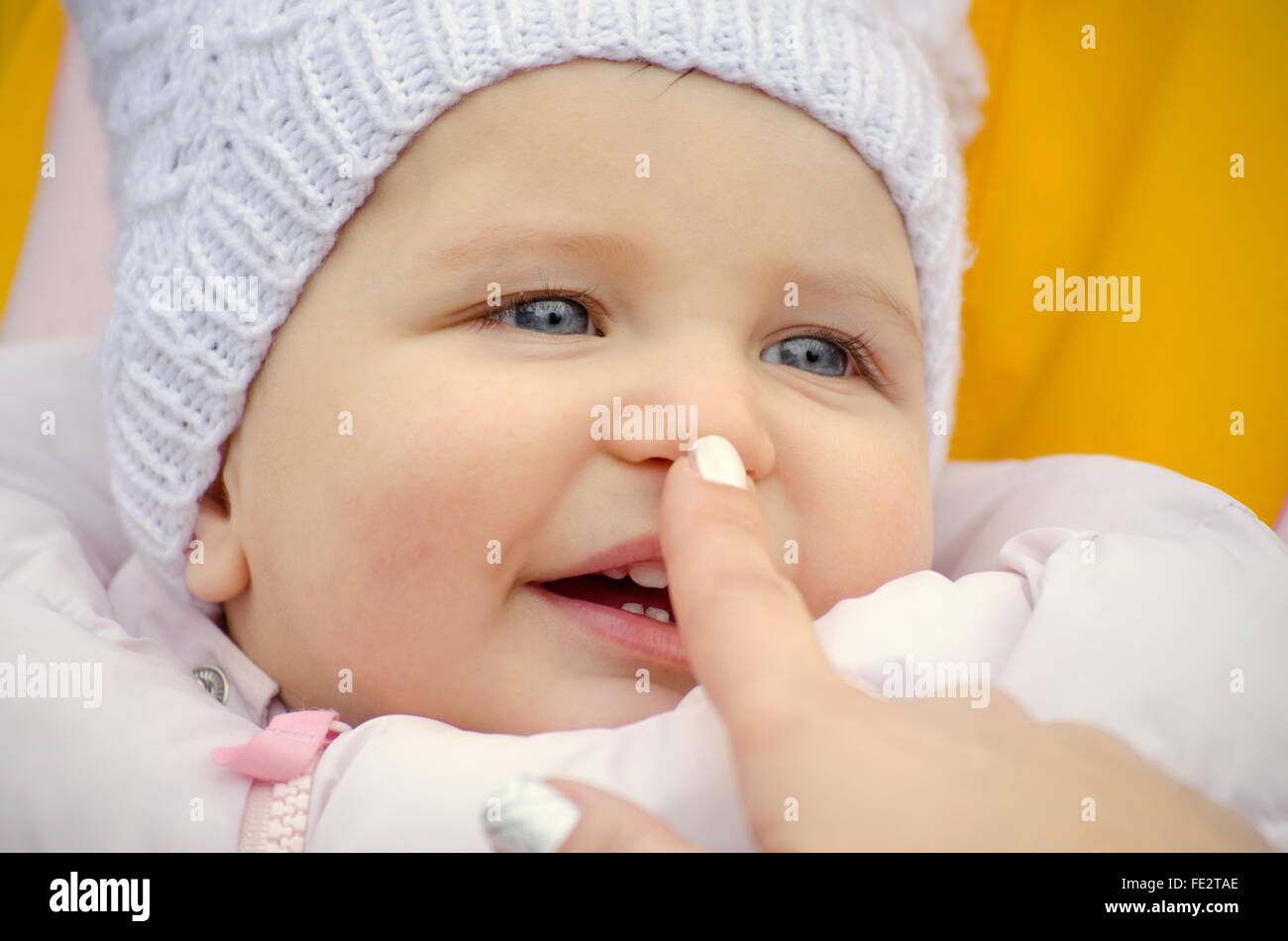 touch a smiling baby's nose Stock Photo