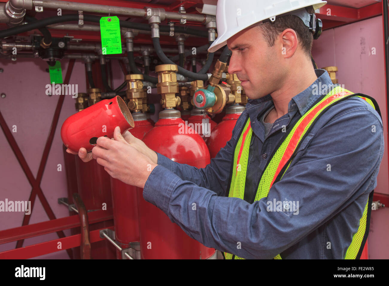 Industrial engineer examining cap for high pressure gas tanks at a power plant Stock Photo