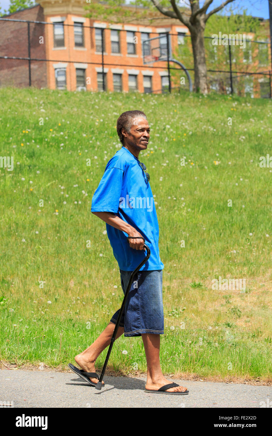 Man with Traumatic Brain Injury taking a walk with his cane Stock Photo