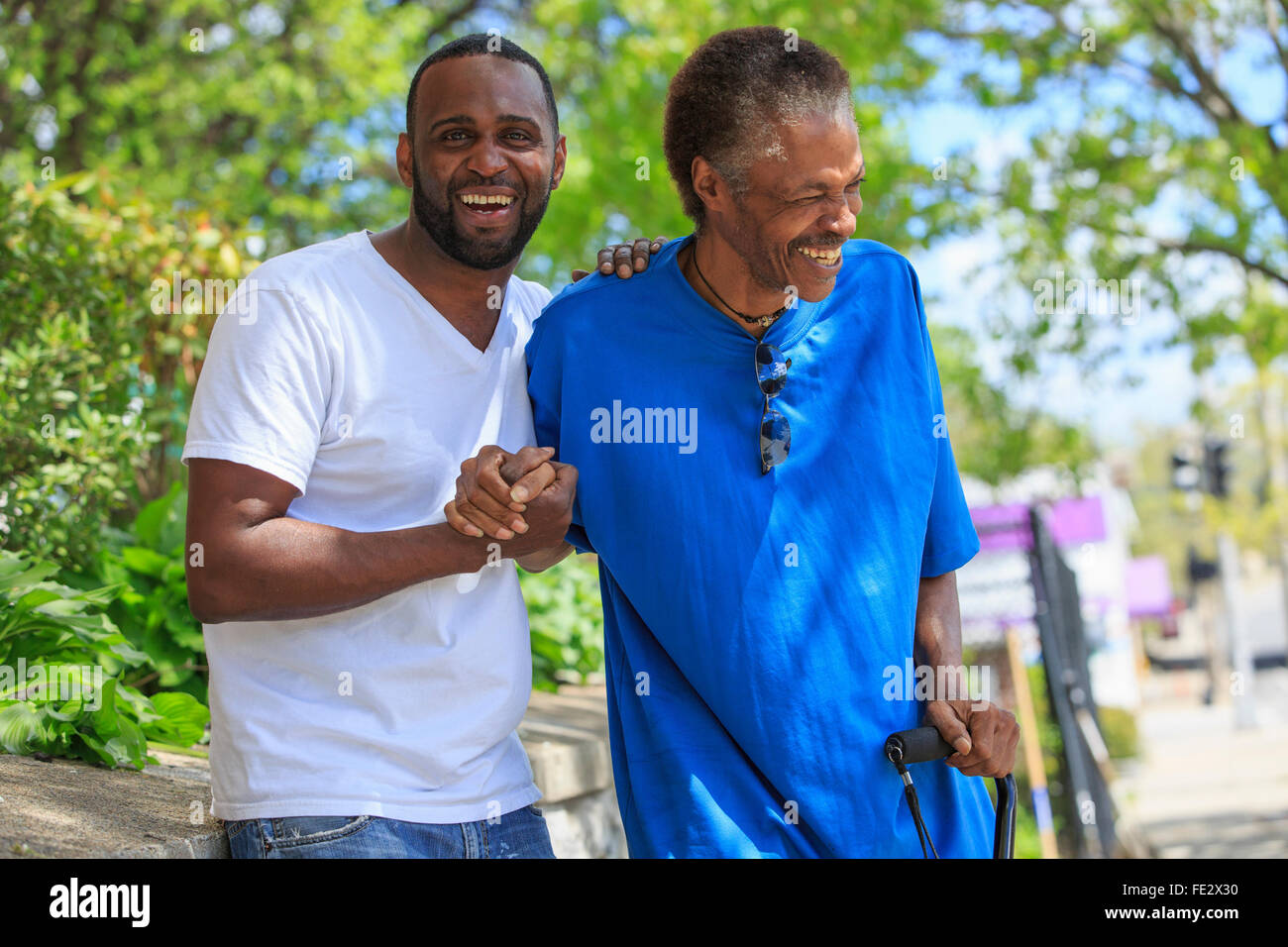 Man with Traumatic Brain Injury with cane enjoying his friend Stock