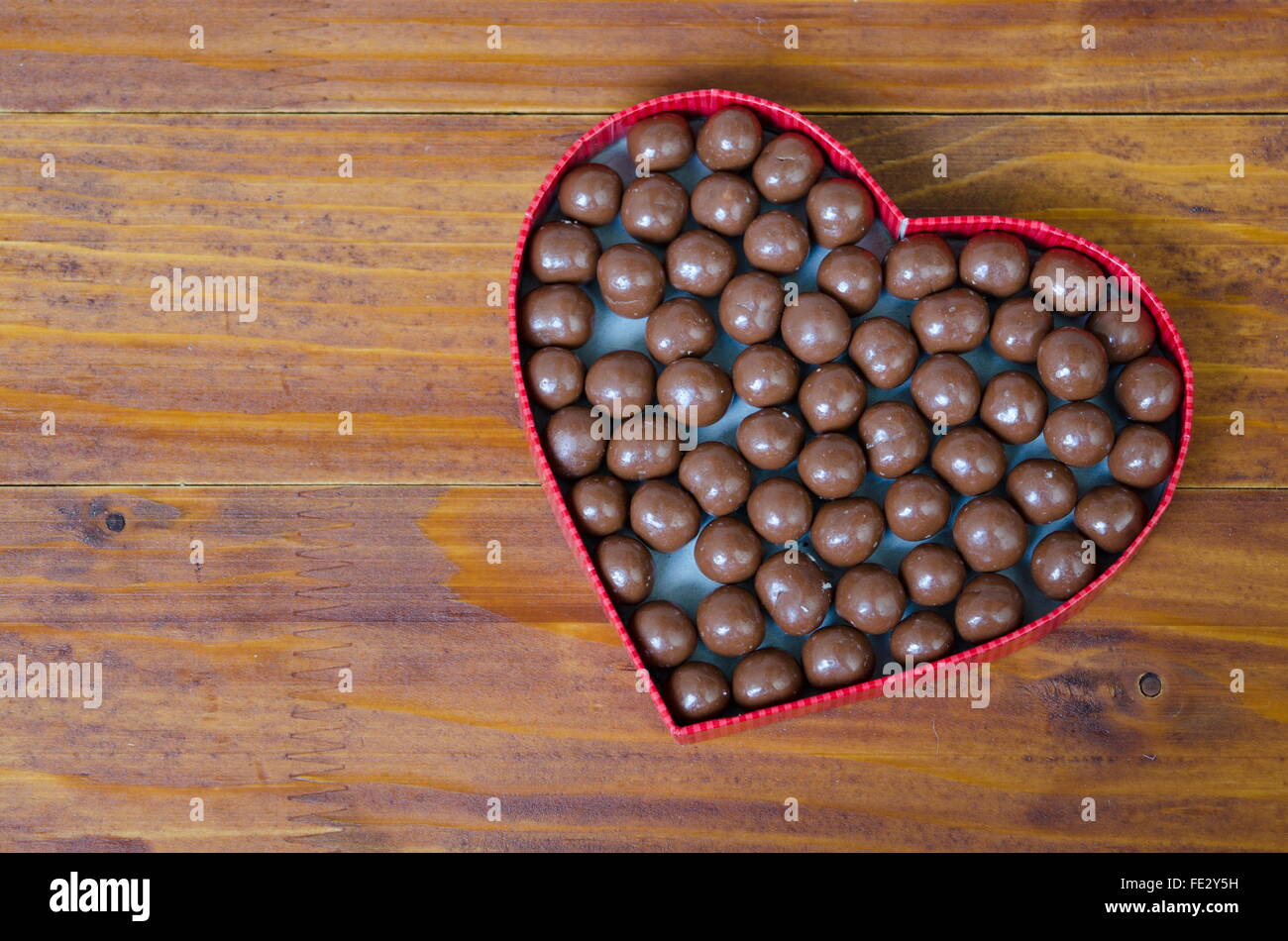 Heart shaped box filled with small chocolates balls Stock Photo Alamy