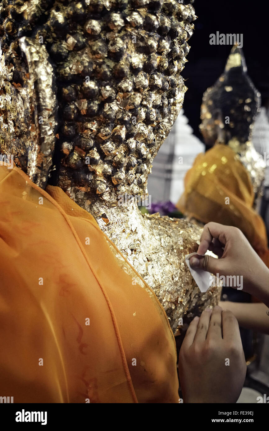 Cropped Image Of Person Cleaning Buddha Statue In Temple Stock Photo