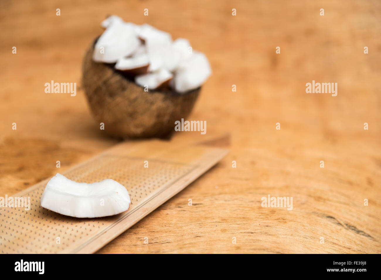 Old coconut cut on wooden background in two parts with negative space Stock Photo