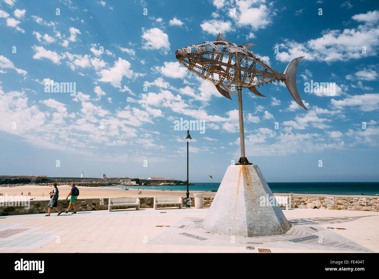 Weather vane in the form of tuna on the background of sunny landscape