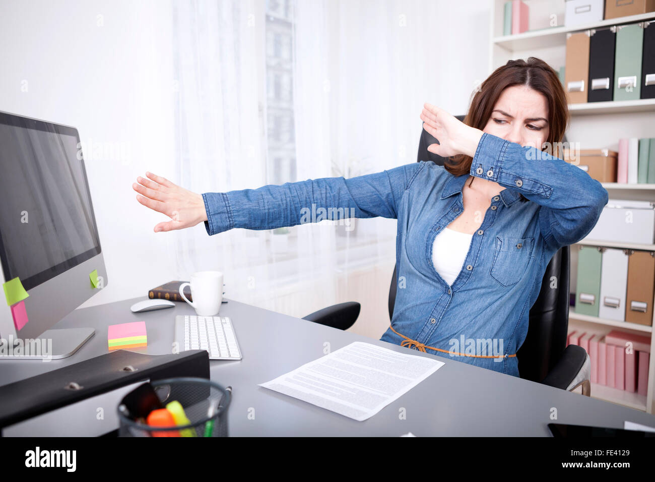 Stressed businesswoman reaching breaking point covering her eyes and pushing her computer monitor away with her hands Stock Photo
