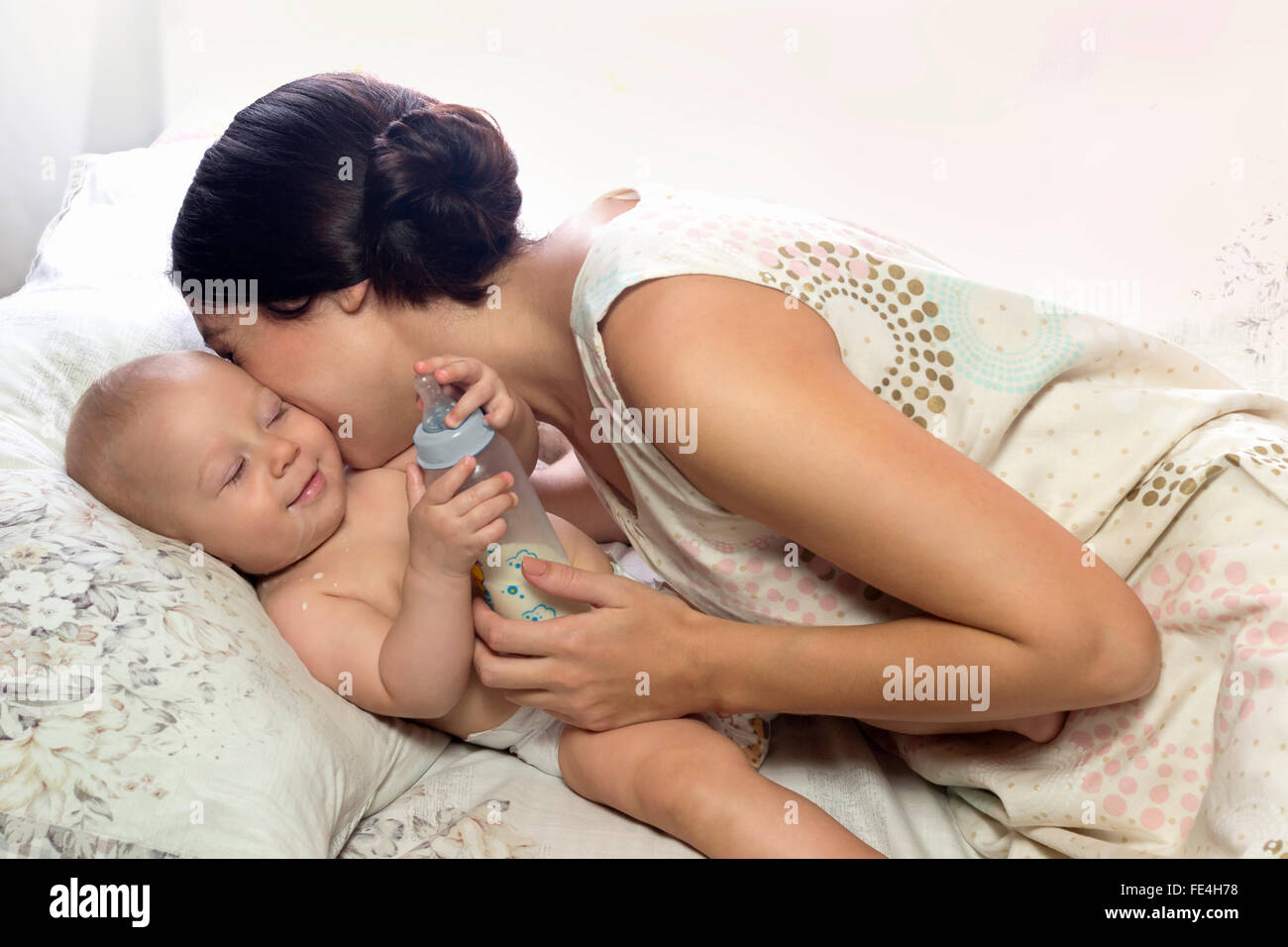 Mom hugging joyful kid. After feeding . At home. Stock Photo