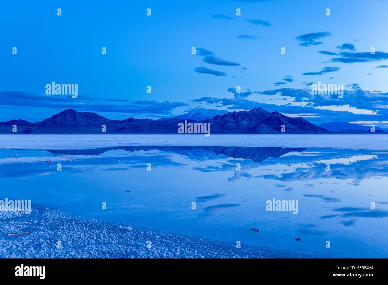 The Silver Island Range is reflected in the salt flat at Bonneville Salt Flats just before sunrise Stock Photo