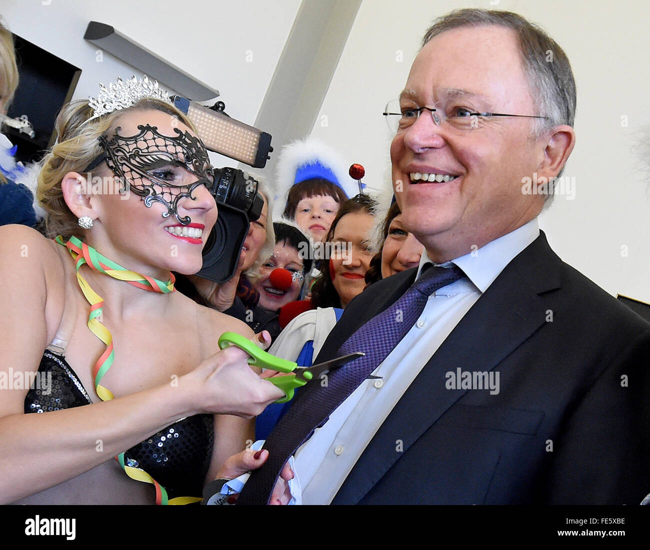 Hanover, Germany. 04th Feb, 2016. Carnival reveller Susan from Linden, Germany (L), cuts off the tie of Stephan Weil (R), premier of the German state Lower Saxony, in his office at the State Chancellery in Hanover, Germany, 04 February 2016. Photo: HOLGER HOLLEMANN/dpa/Alamy Live News Stock Photo