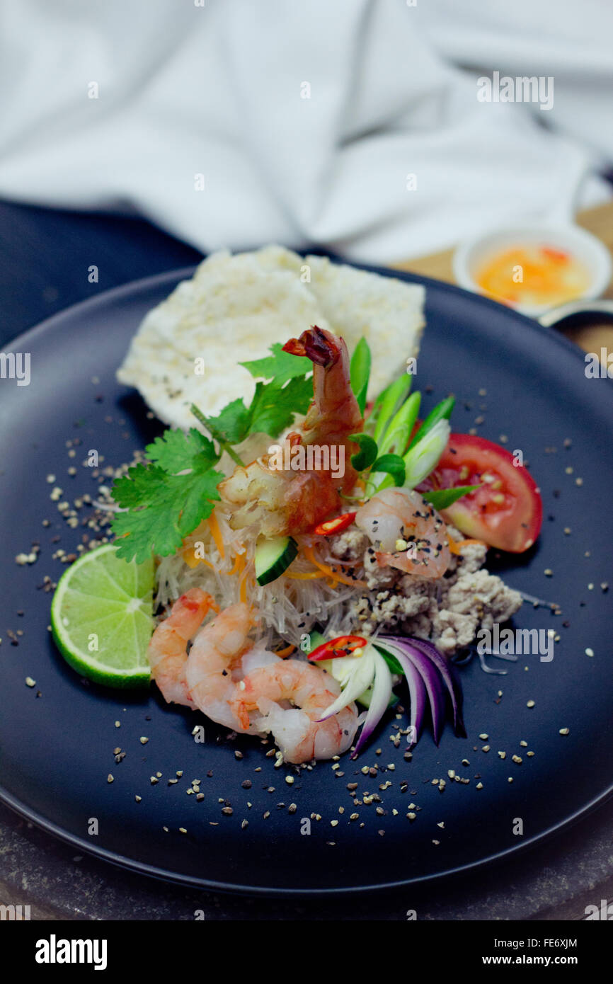 Asian Glass Noodle Salad, Asian Vermicelli, served with Kropoek, Gamba and Shrimps decorated with Pepper and Cilantro Stock Photo