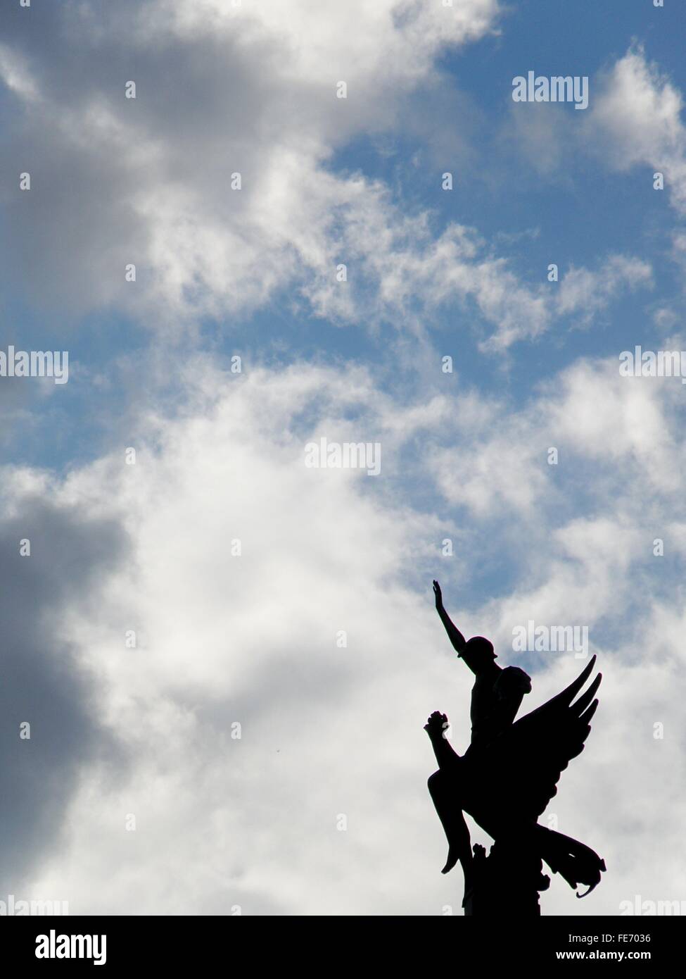 Silhouette Fallen Angel Statue Against Cloudy Sky Stock Photo