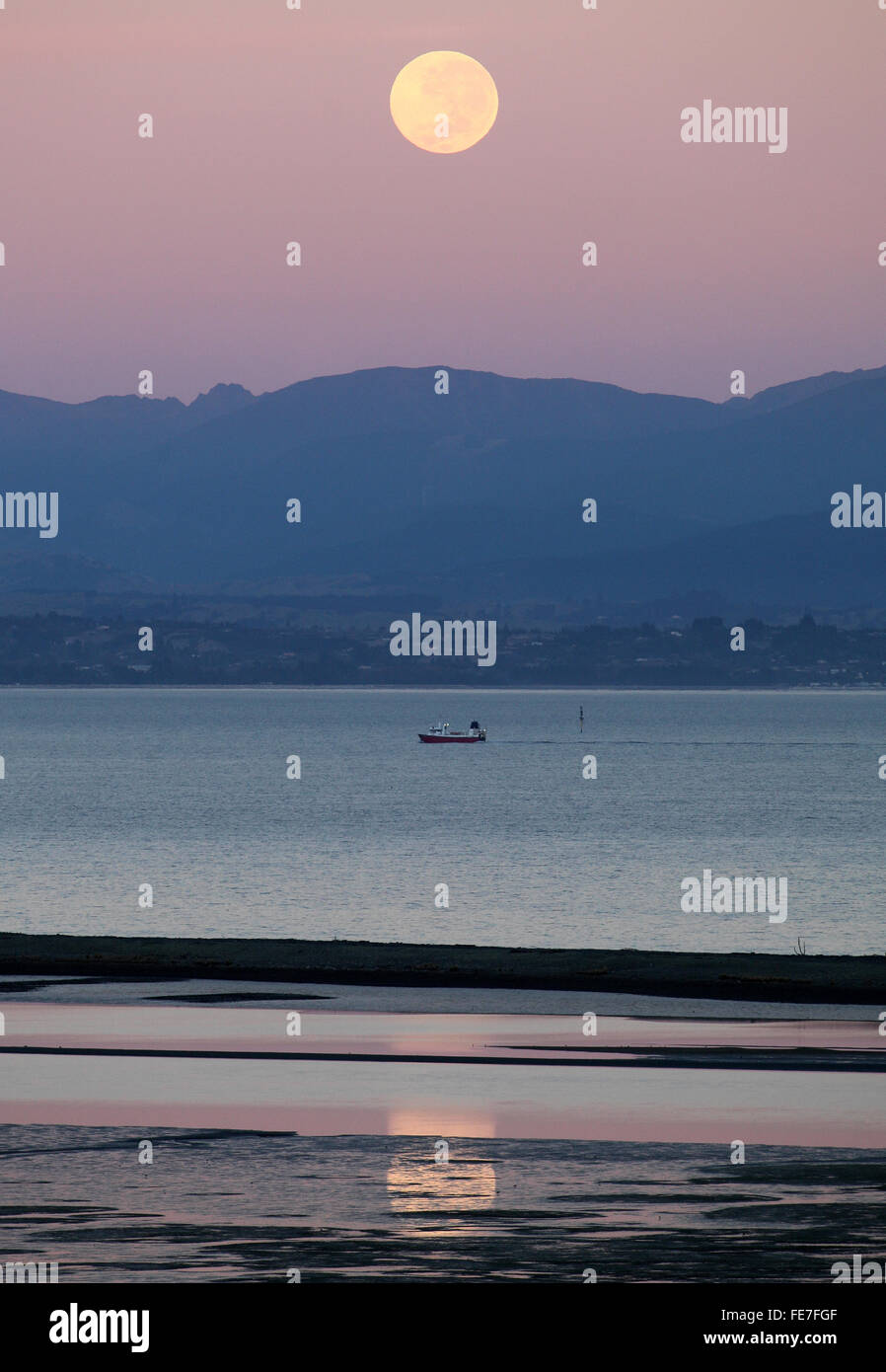 Full moon setting over a fishing vessel in Tasman Bay, Nelson , New