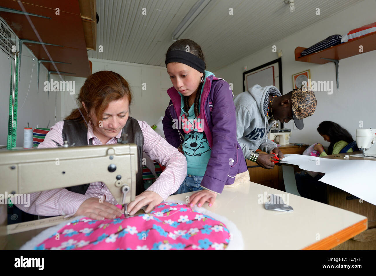 Girl and teacher using sewing machine, tailoring, vocational training, Creciendo Unidos social project, Javier Villa, Bogotá Stock Photo