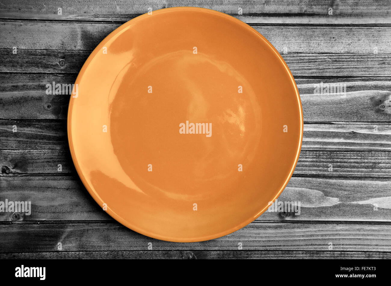 Empty orange plate on gray wooden table Stock Photo