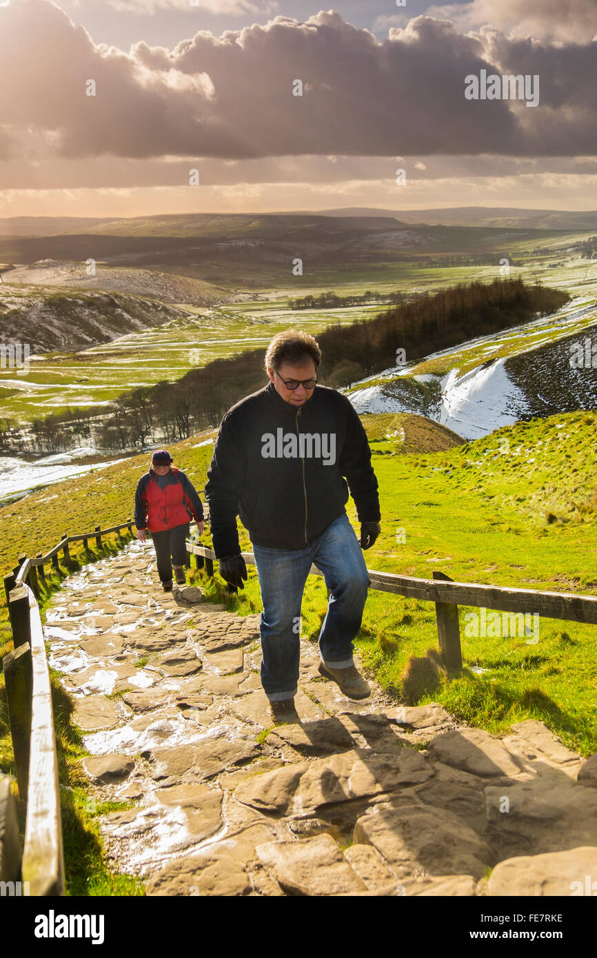 Walkers climb the stone steps leading from the car park to the summit of Mam Tor. Stock Photo