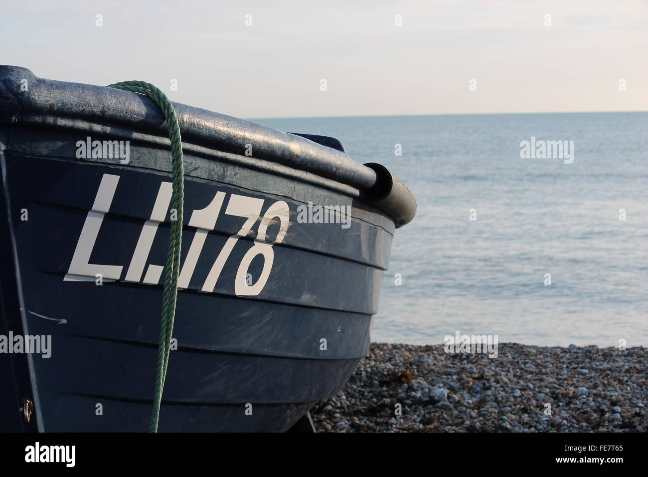 Fishing boat on pebble beach shore Stock Photo - Alamy