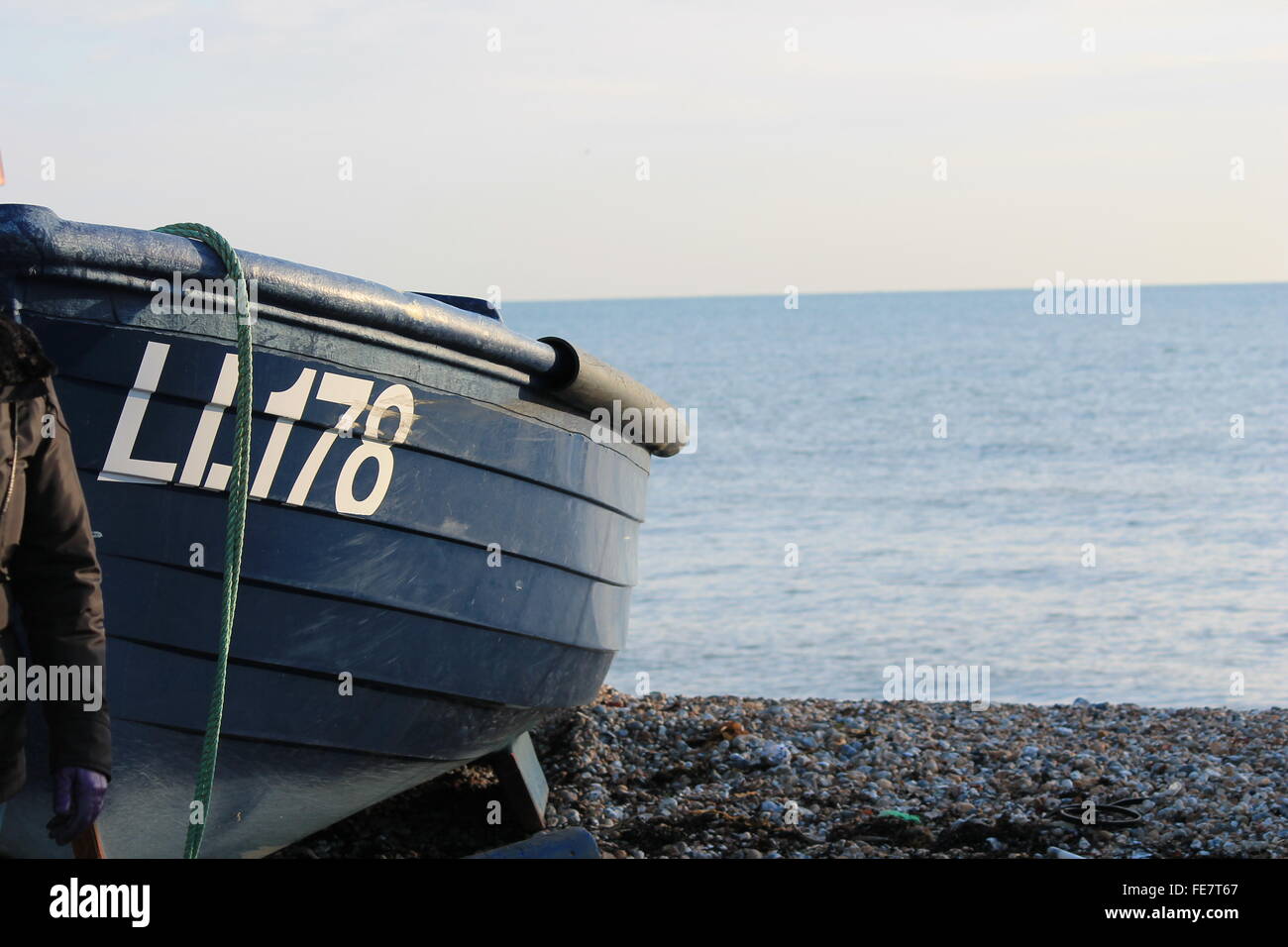 Fishing boat on pebble beach shore Stock Photo - Alamy