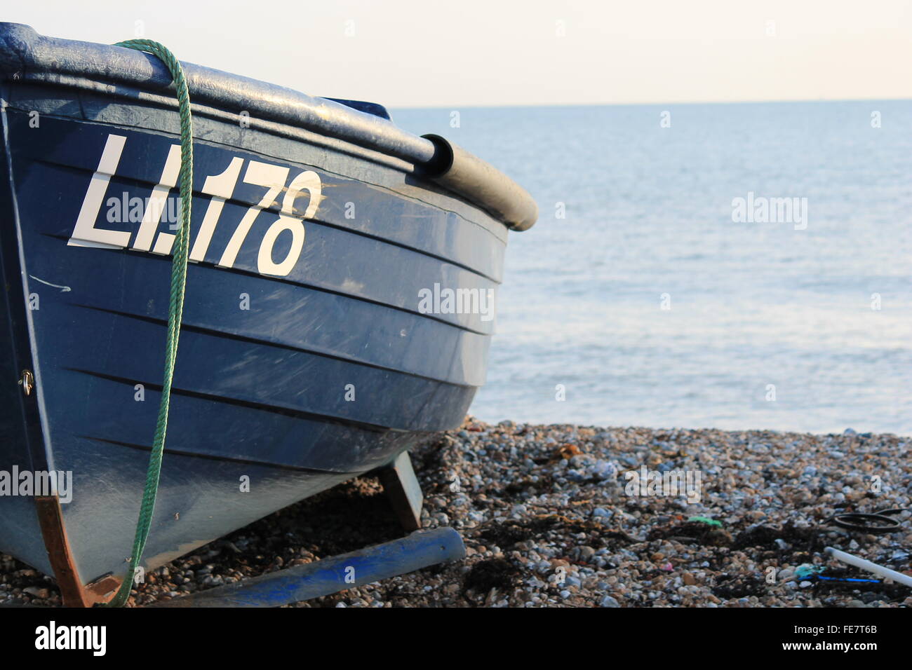 Fishing boat on pebble beach shore Stock Photo - Alamy