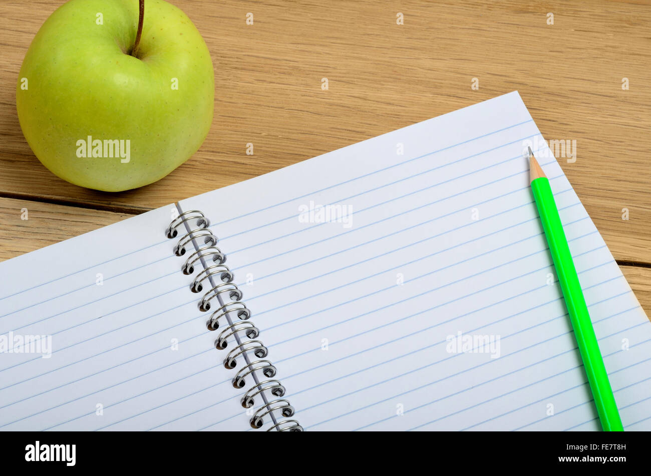 Blank notebook with apple fruit on wooden table Stock Photo