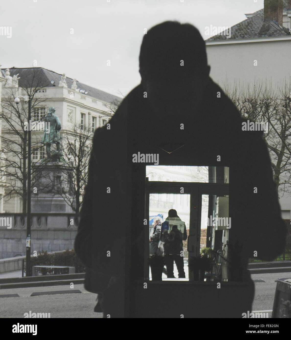 Reflection Of Silhouette Man On Glass Window In City Stock Photo