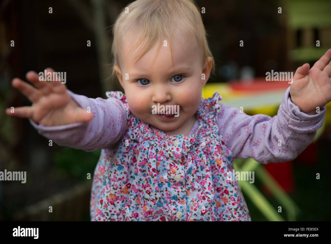 Young blond girl learning to walk. Stock Photo