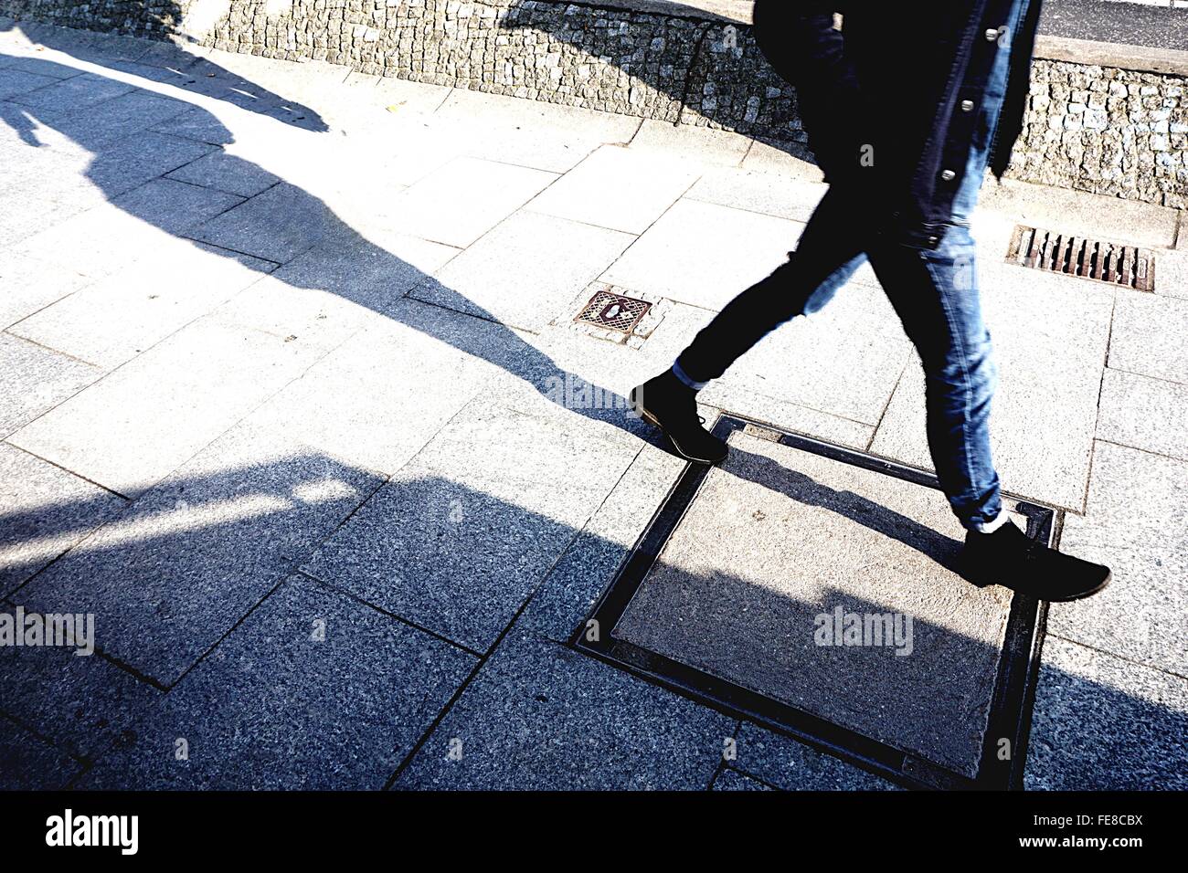 Low Section View Of Person Walking On Sidewalk Stock Photo