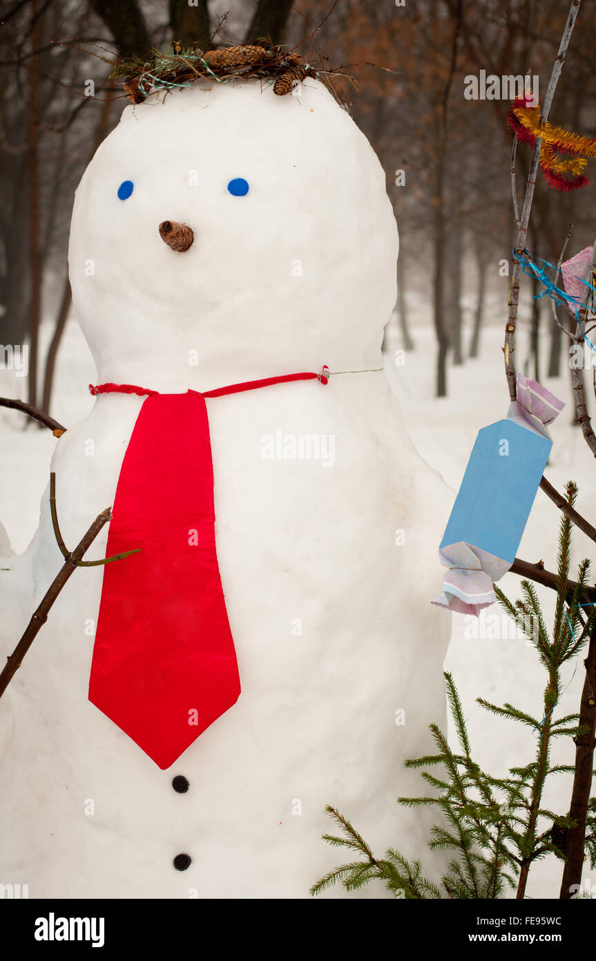 cute snowman with red tie, blue eyes and pine cone Stock Photo