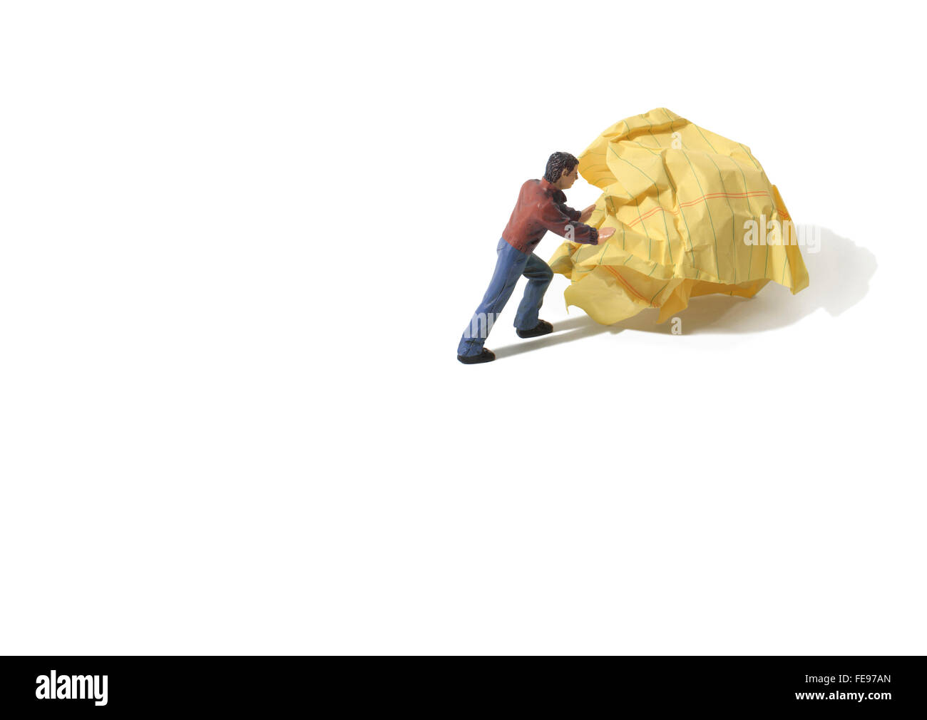 Figure Pushing a Yellow Crumpled Paper Wad on a White Background Stock Photo
