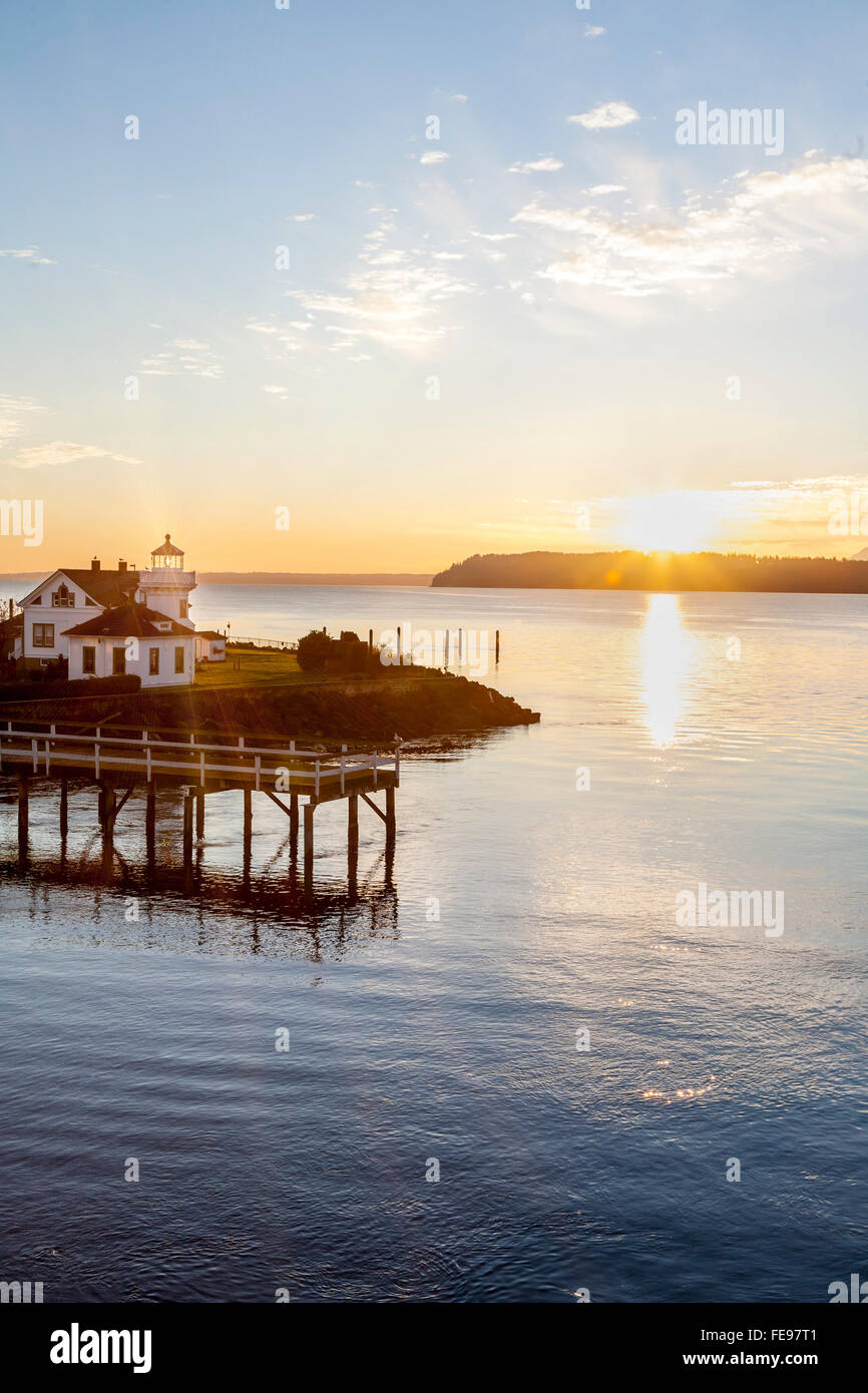 Mukilteo lighthouse and Puget Sound at sunset with Whidbey Island in the distance, Washington State. Beautiful Pacific Northwest travel destinations. Stock Photo