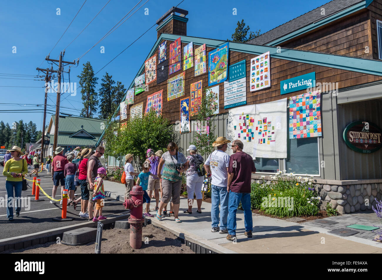 Visitors look at quilts displayed at the Sisters Outdoor Quilt Show