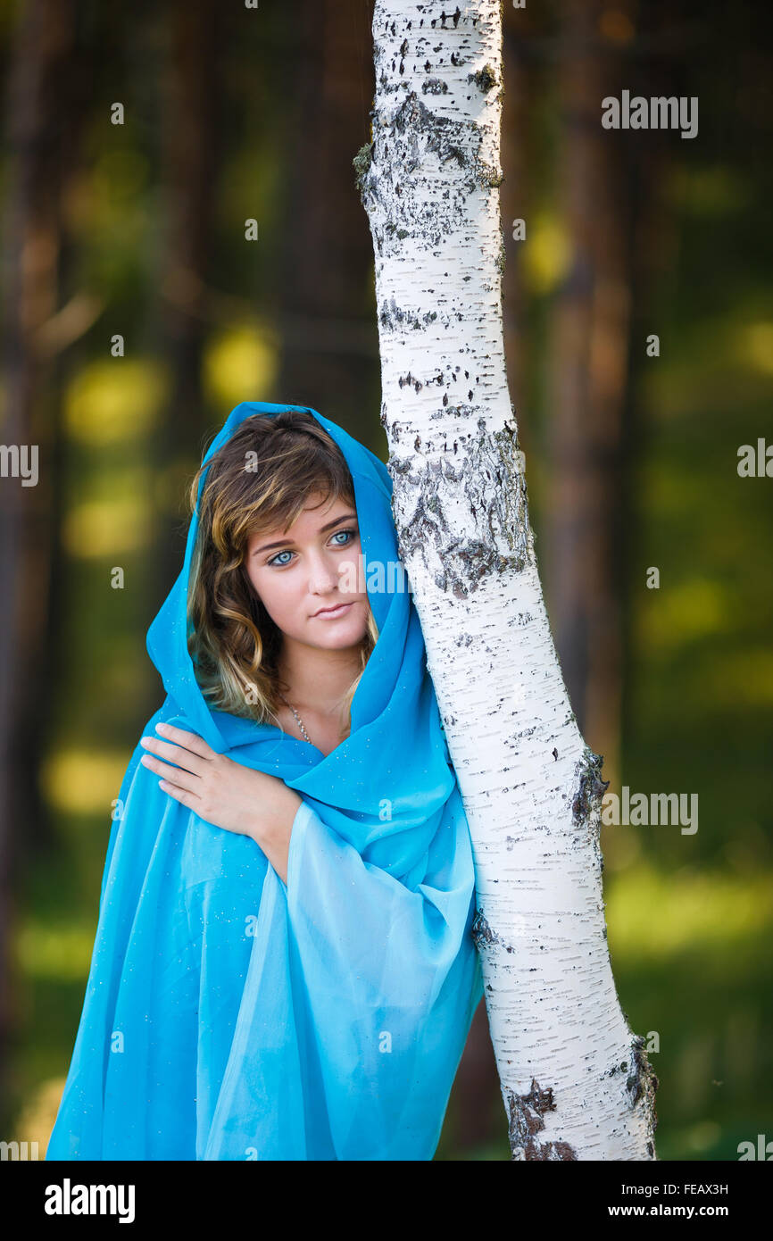 Portrait of attractive young girl in blue sari covered her head in a forest Stock Photo