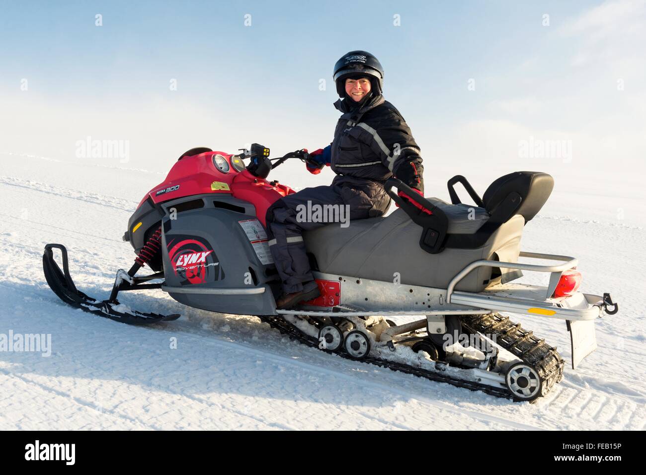 Woman on snowmobile on glacier in Iceland. Stock Photo