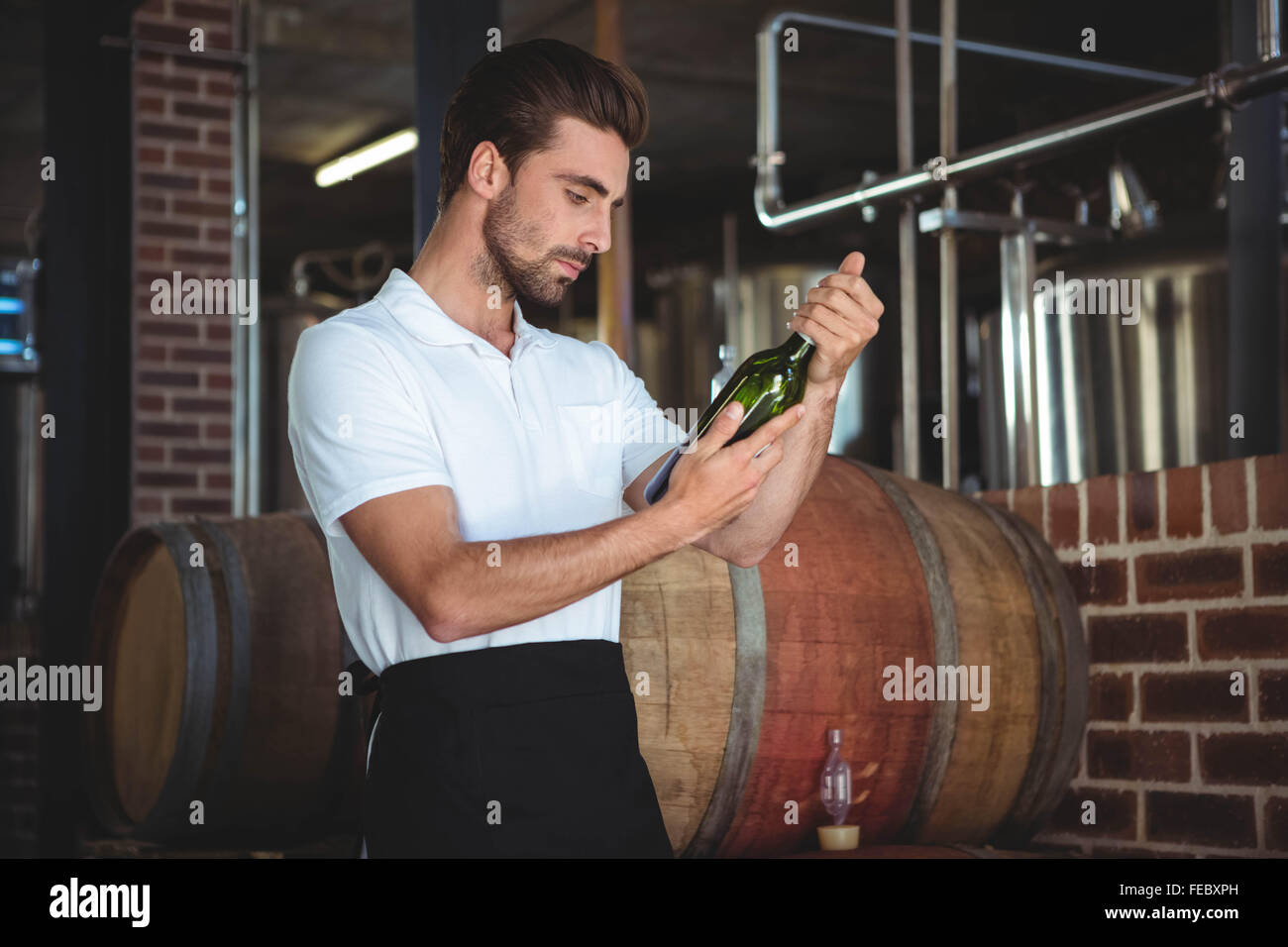 Handsome brewer checking at a wine bottle Stock Photo Alamy