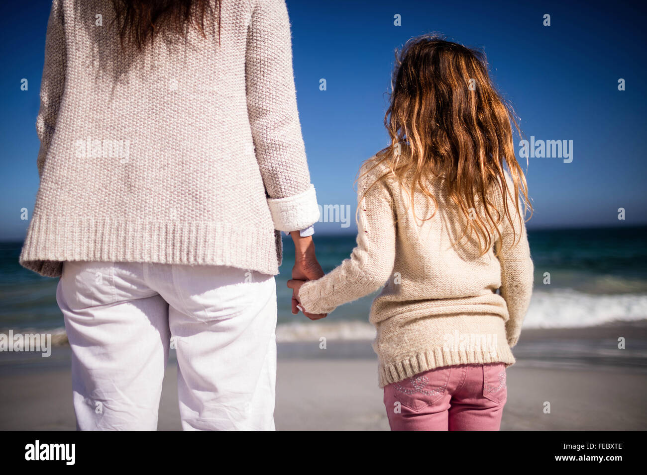 Mother and daughter holding hands Stock Photo - Alamy