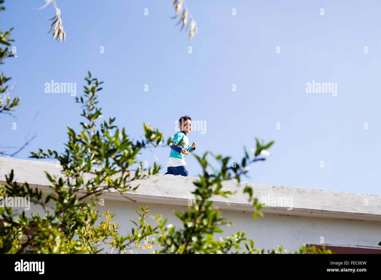 A boy playfully runs on the roof in Bezigan a rural village near Kalkan, Lycian Way, Turkey Stock Photo