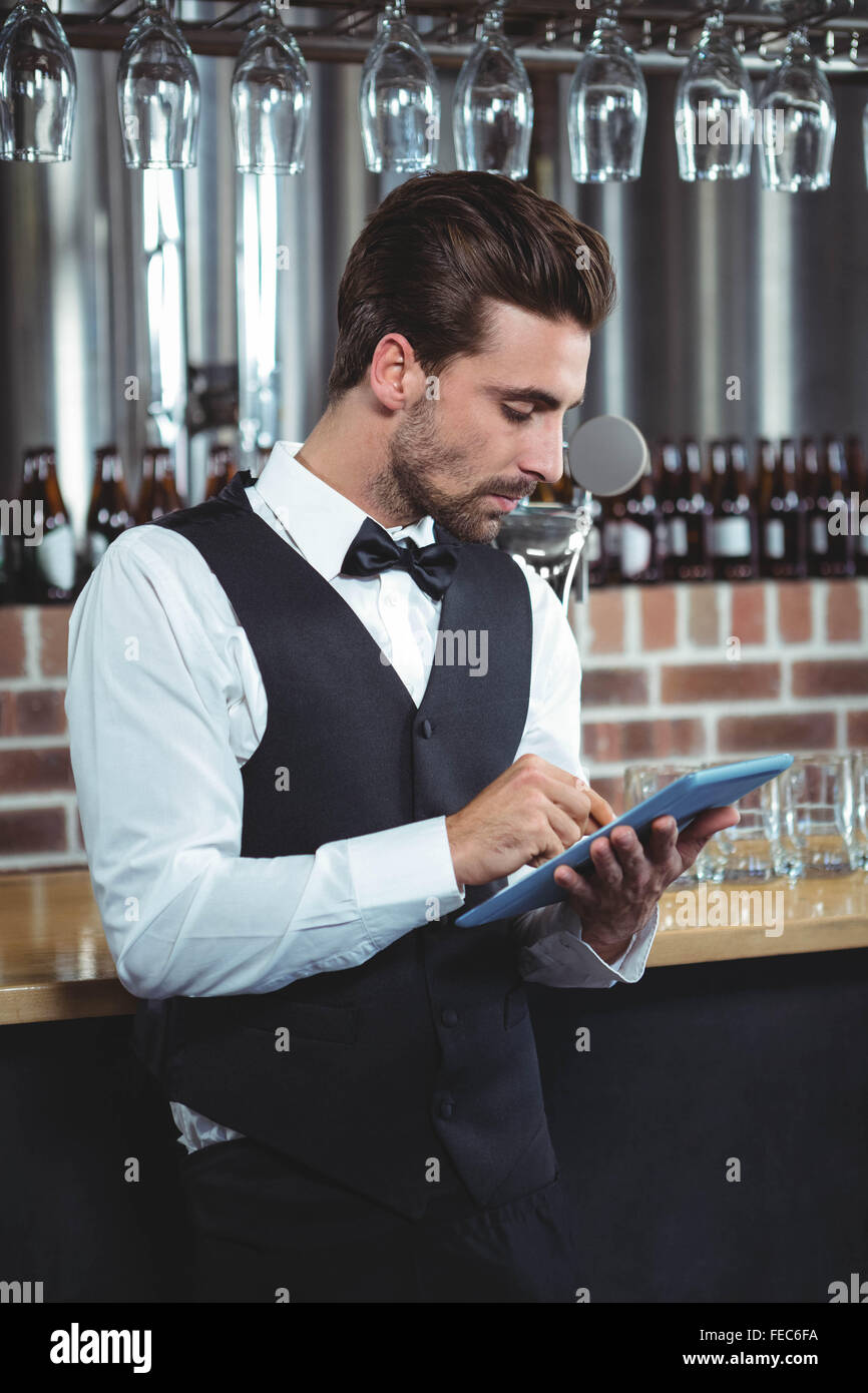 Handsome barman using tablet computer Stock Photo