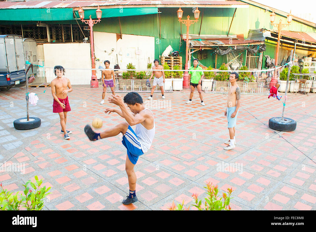 Thai men and boys playing Sepak Takraw or Kick Volleyball a volleyball game but with their feet in Bangkok, Thailand. Stock Photo