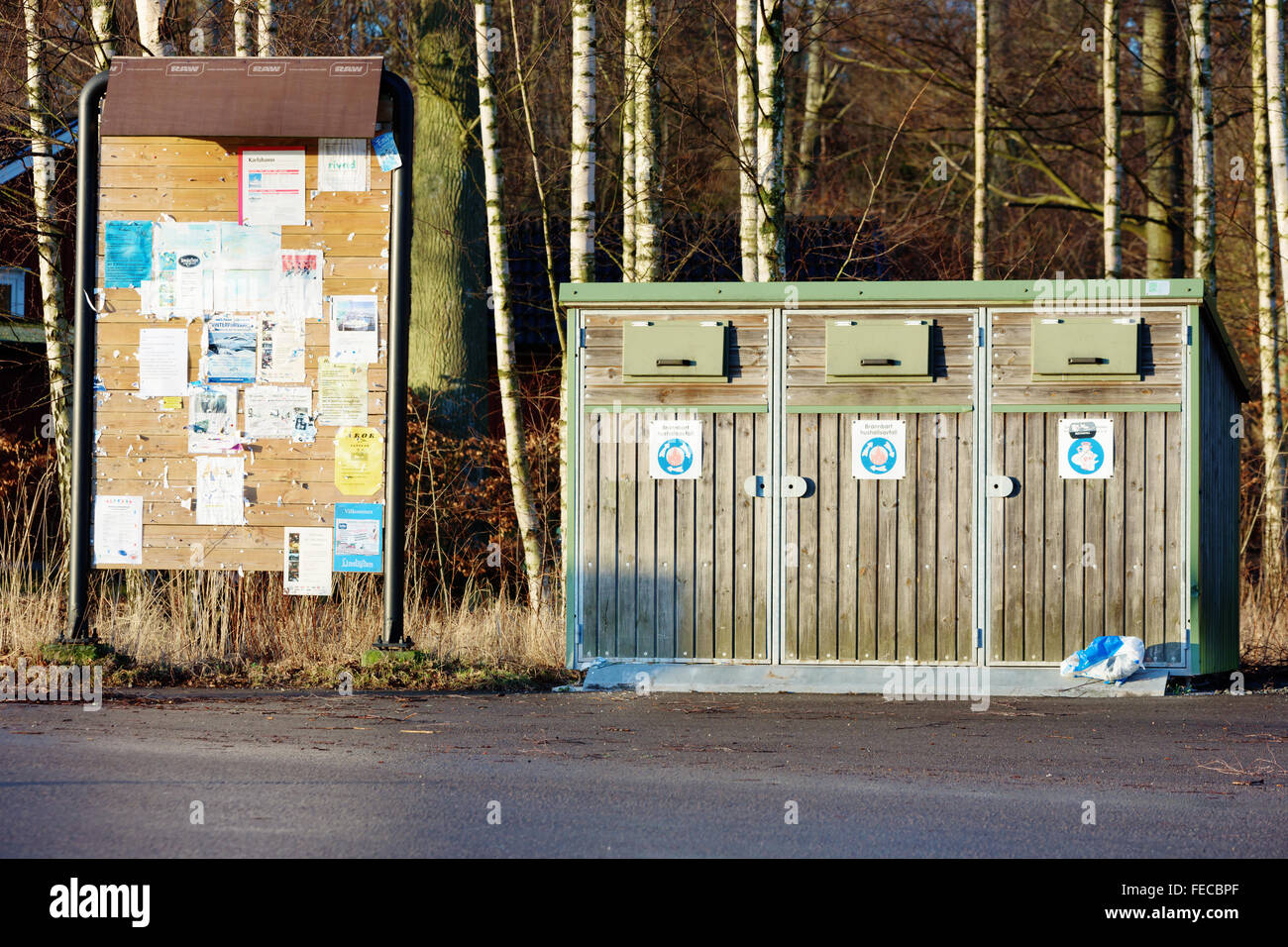 Karlshamn, Sweden - February 04, 2016: A notice board full of messages and a small waste station with forest in background. Stre Stock Photo