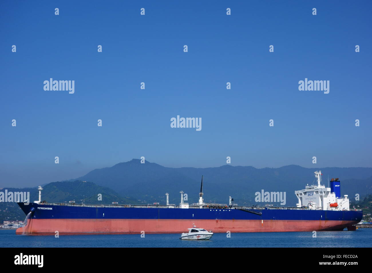 Oil tanker and a coast guard vessel in Batumi oil terminal on a sunny summer day. Stock Photo