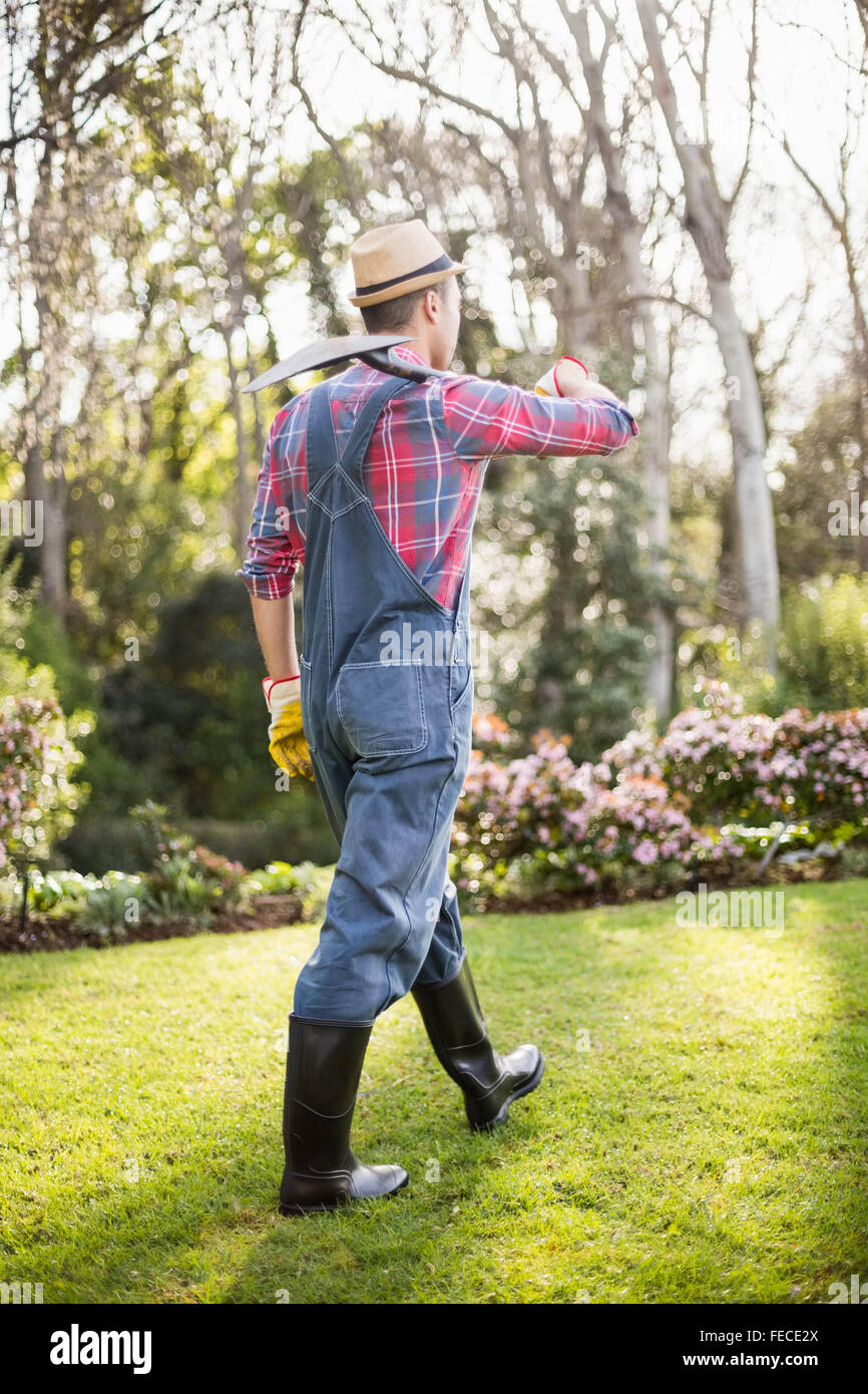 Gardener man walking with his shovel Stock Photo - Alamy