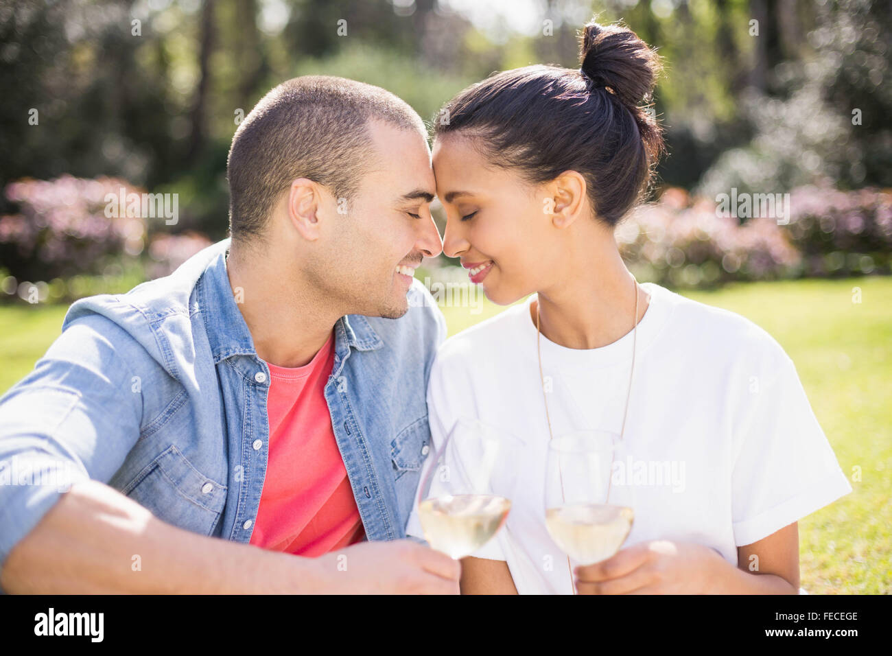 Smiling couple drinking wine on picnic blanket Stock Photo - Alamy