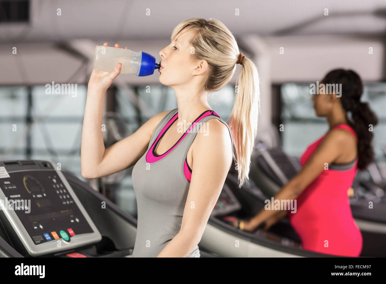 Fit blonde drinking water on treadmill Stock Photo Alamy