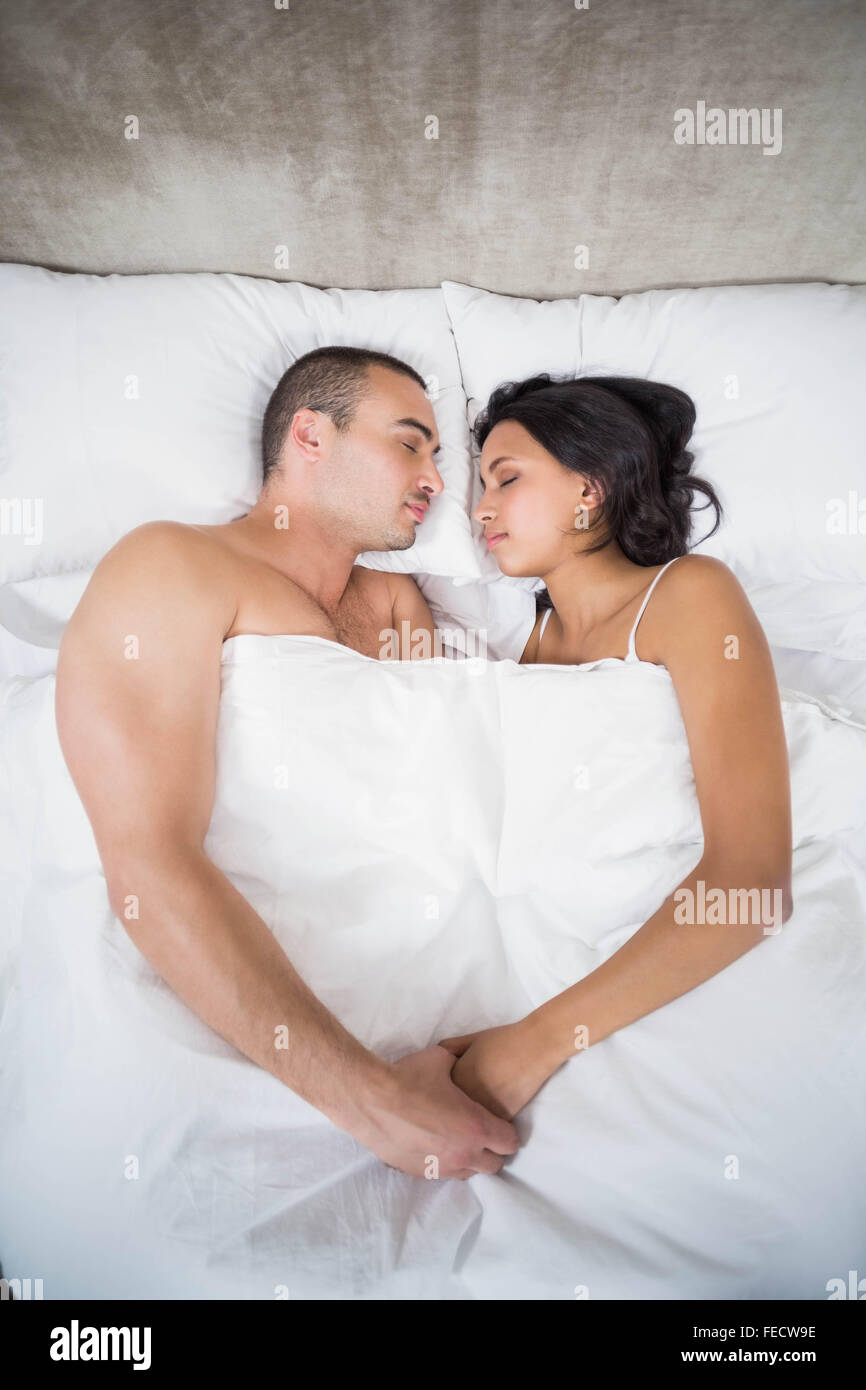 Young couple sleeping and holding hands in bed Stock Photo - Alamy