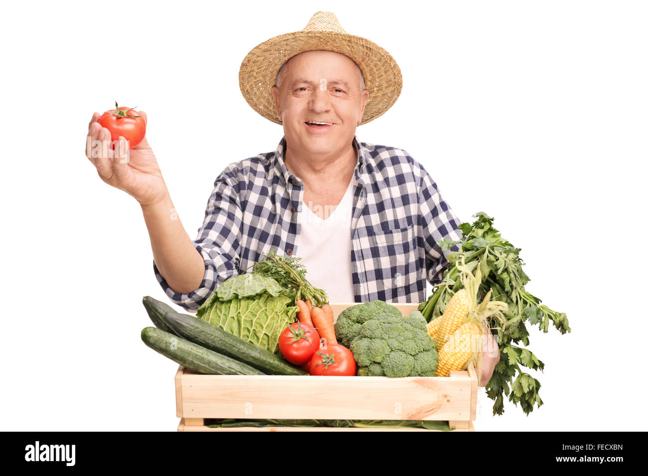 Mature farmer standing behind a wooden crate full of vegetables and ...