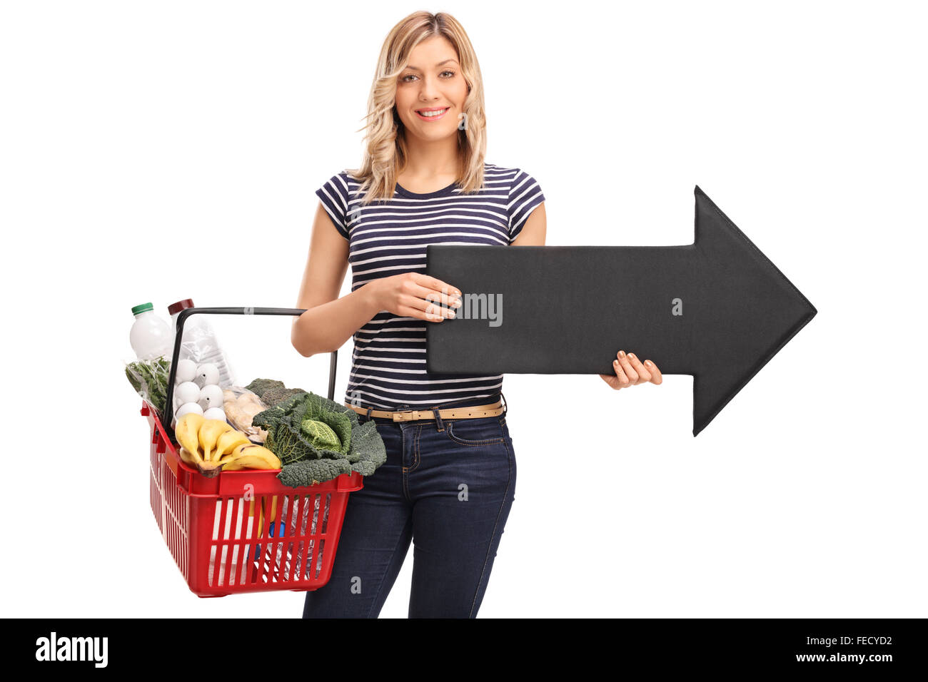 Young woman holding a shopping basket and a big black arrow pointing ...