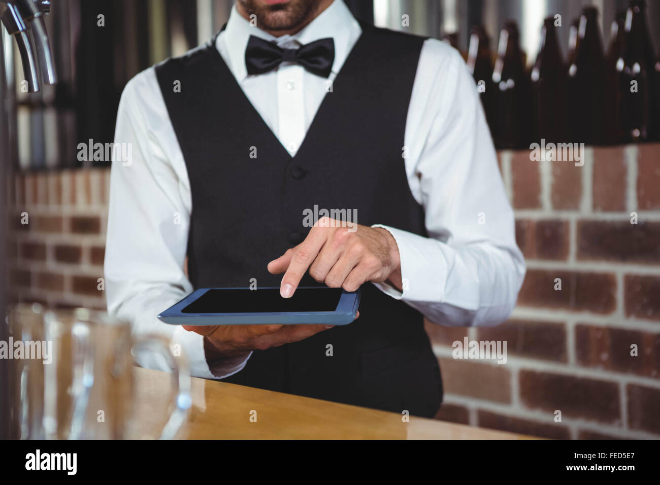 Handsome barman using tablet computer Stock Photo