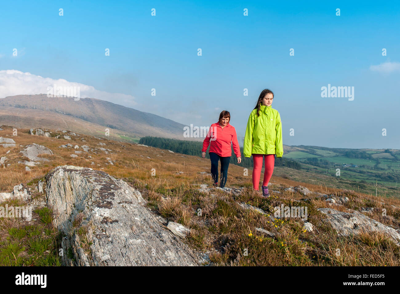 Two female hillwalkers walk on hills near Ballydehob, West Cork, Ireland. Stock Photo