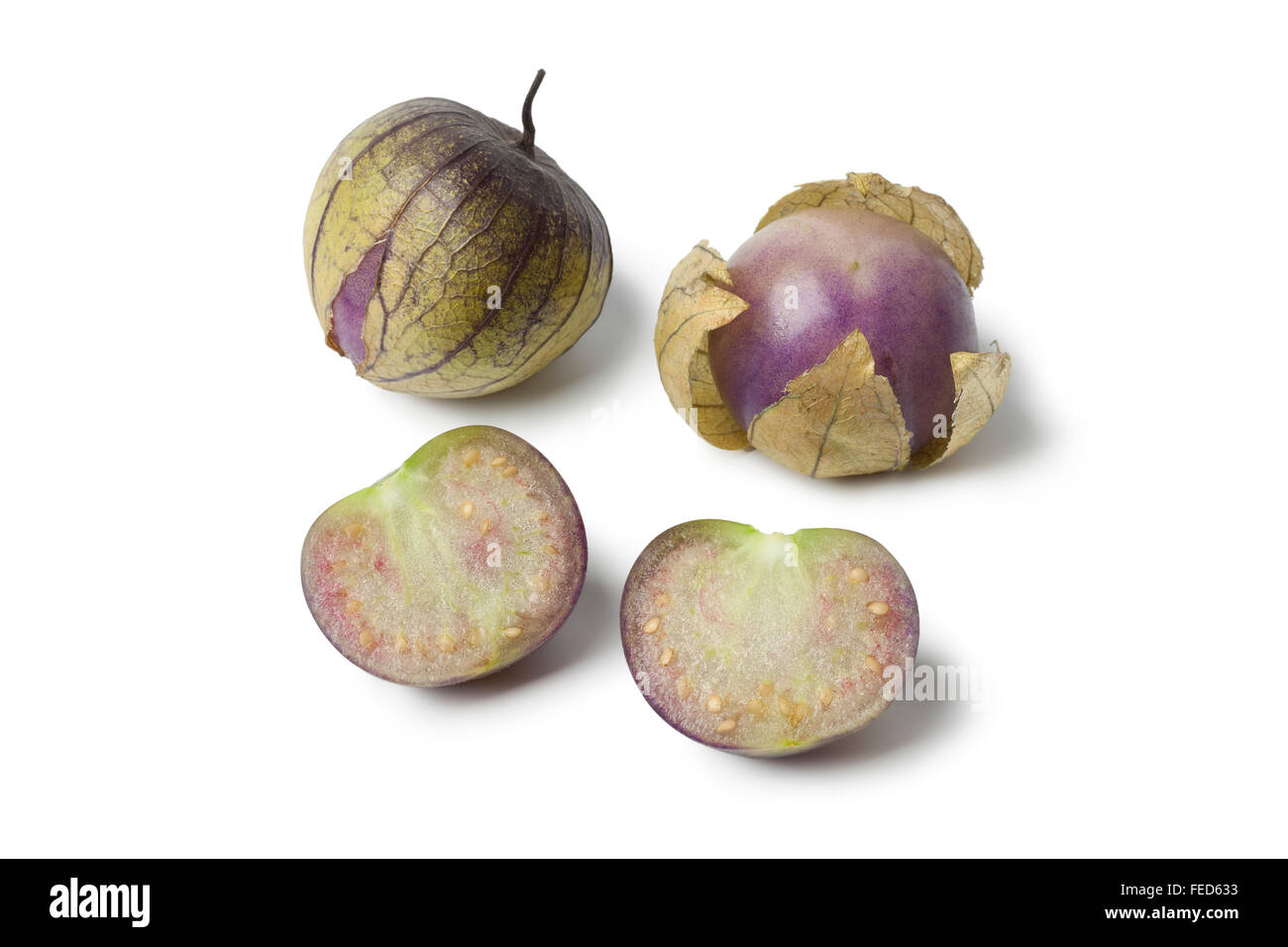 Fresh whole and half tomatillos in their husk on white background Stock Photo