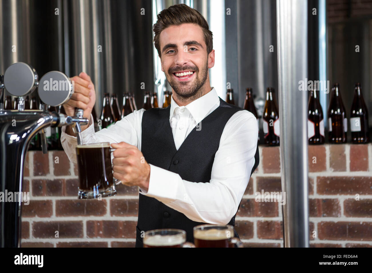Barman pouring a pint of beer Stock Photo