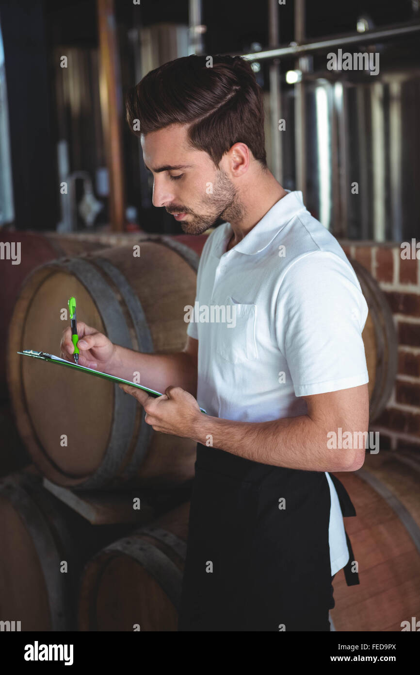 Winemaker taking notes on clipboard Stock Photo