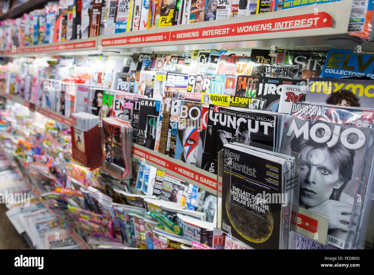 Stacks of glossy magazines in a newsagent shop in London.Music magazines and Women's interests Stock Photo